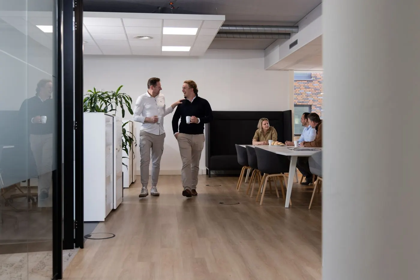 Doorkijk in het kantoor van bufr met collega’s in overleg