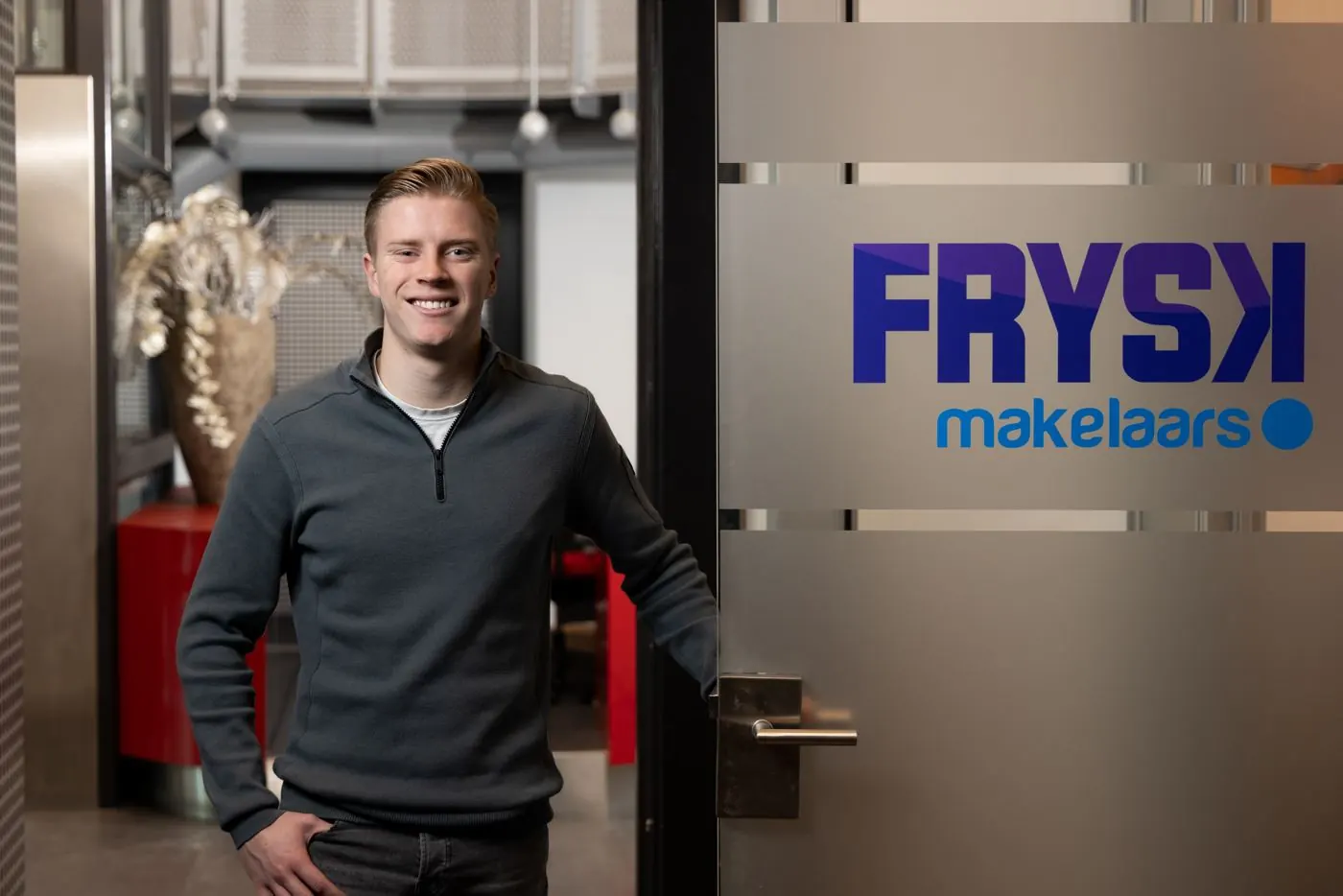 Collega van FRYSK makelaars bij de entree met het logo
